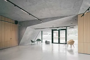 Modernes Besucherzentrum mit mineralischer Fassade im Einklang mit der Berglandschaft.