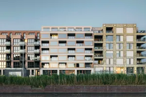 Kanalfassade des Wohngebäudes Prisma in Delft mit hellen Putzelementen und tiefen Loggien