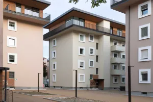 Renoviertes Wohngebäude mit hellen Fassaden, Balkonen und modernisierten Architekturdetails.