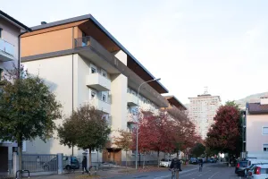 Straßenansicht eines älteren Wohngebäudes vor der Sanierung, mit heller Fassade und Holzläden.