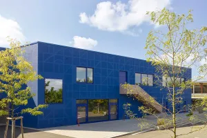 Moderner Gebäudekomplex mit künstlerisch gestalteter blauer Fassade.