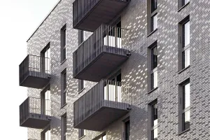 Closeup Keramikfassade mit grauen StoCera Keramikfliesen mit Fenstern, neues Sportlerhaus in Hamburg. 