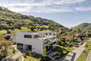 Modern white museum building of the Schütz Art Museum in Engelhartszell, featuring an open frame structure and large glass façades.