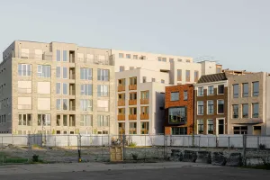 Platzfassade des Wohngebäudes Prisma in Delft mit bodentiefen zweiflügeligen Fenstertüren