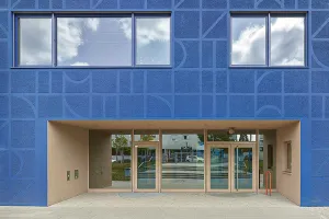 Moderner Gebäudekomplex mit künstlerisch gestalteter blauer Fassade.