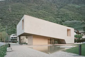 Modernes Besucherzentrum mit mineralischer Fassade im Einklang mit der Berglandschaft.