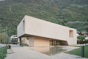 Modernes Besucherzentrum mit mineralischer Fassade im Einklang mit der Berglandschaft.
