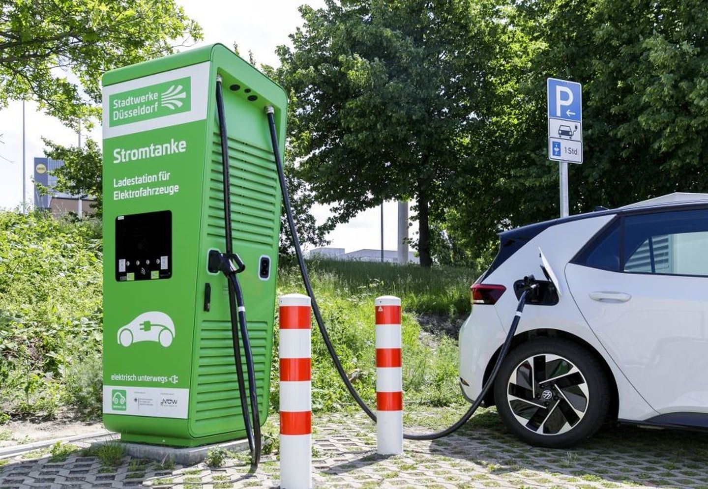 Ein Parkplatz, auf dem ein Auto zum Ladevorgang angeschlossen ist.