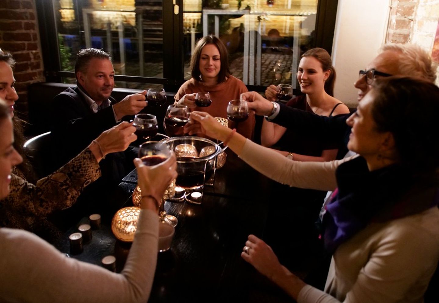 Eine Feuerzangenbowle-Zeremonie findet ihren Höhepunkt im Anstoßen und dem anschließenden geselligen Beieinandersein in der Gruppe.