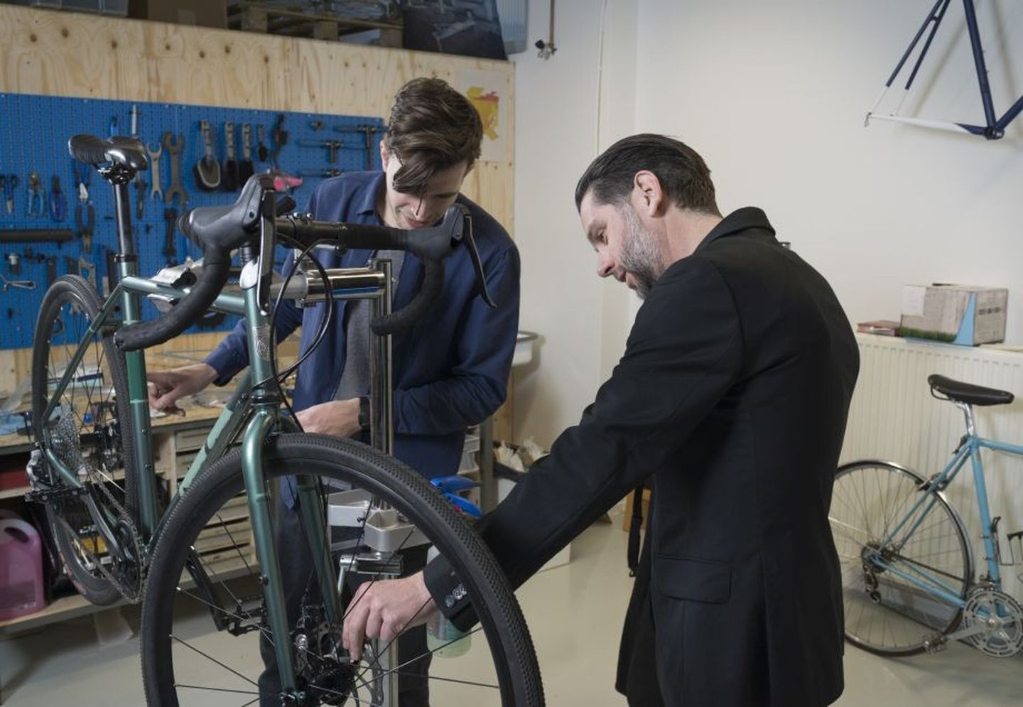 Zwei Männer prüfen die Schäden eines Fahrrads, um es dann im Repair Café zu reparieren.