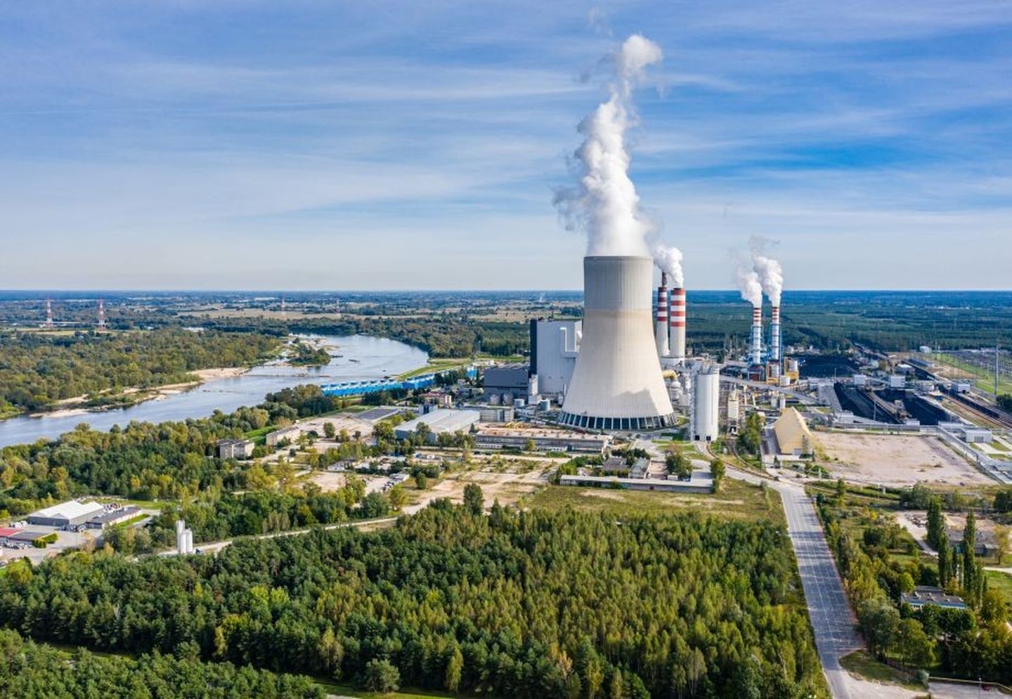 Ein Kraftwerk erzeugt Abwärme, die in Form von Dampfwolken in den Himmel steigt. 