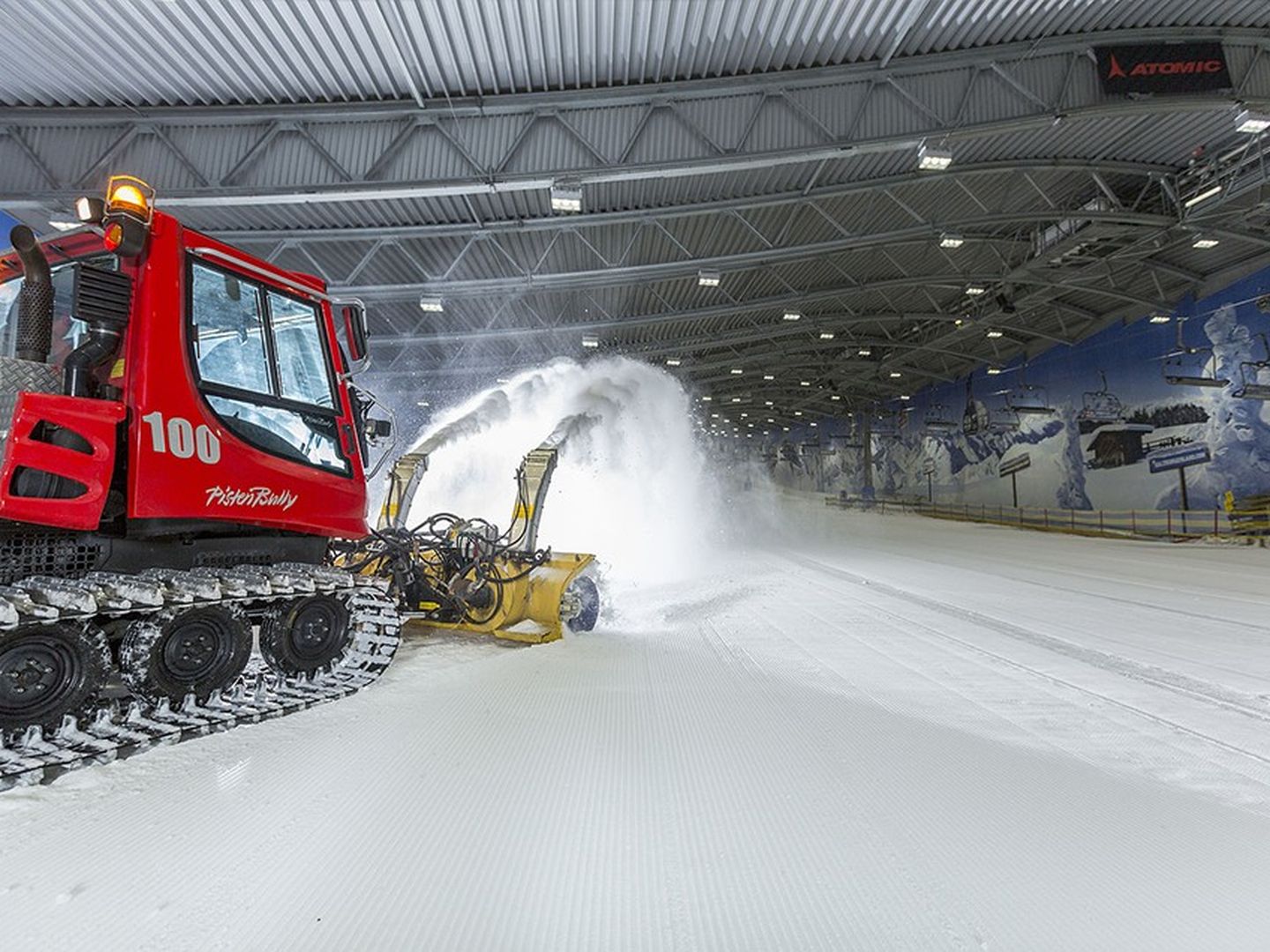 Auch in der Halle bereitet eine Pistenraupe den Kunstschnee für die nächste Abfahrt vor.