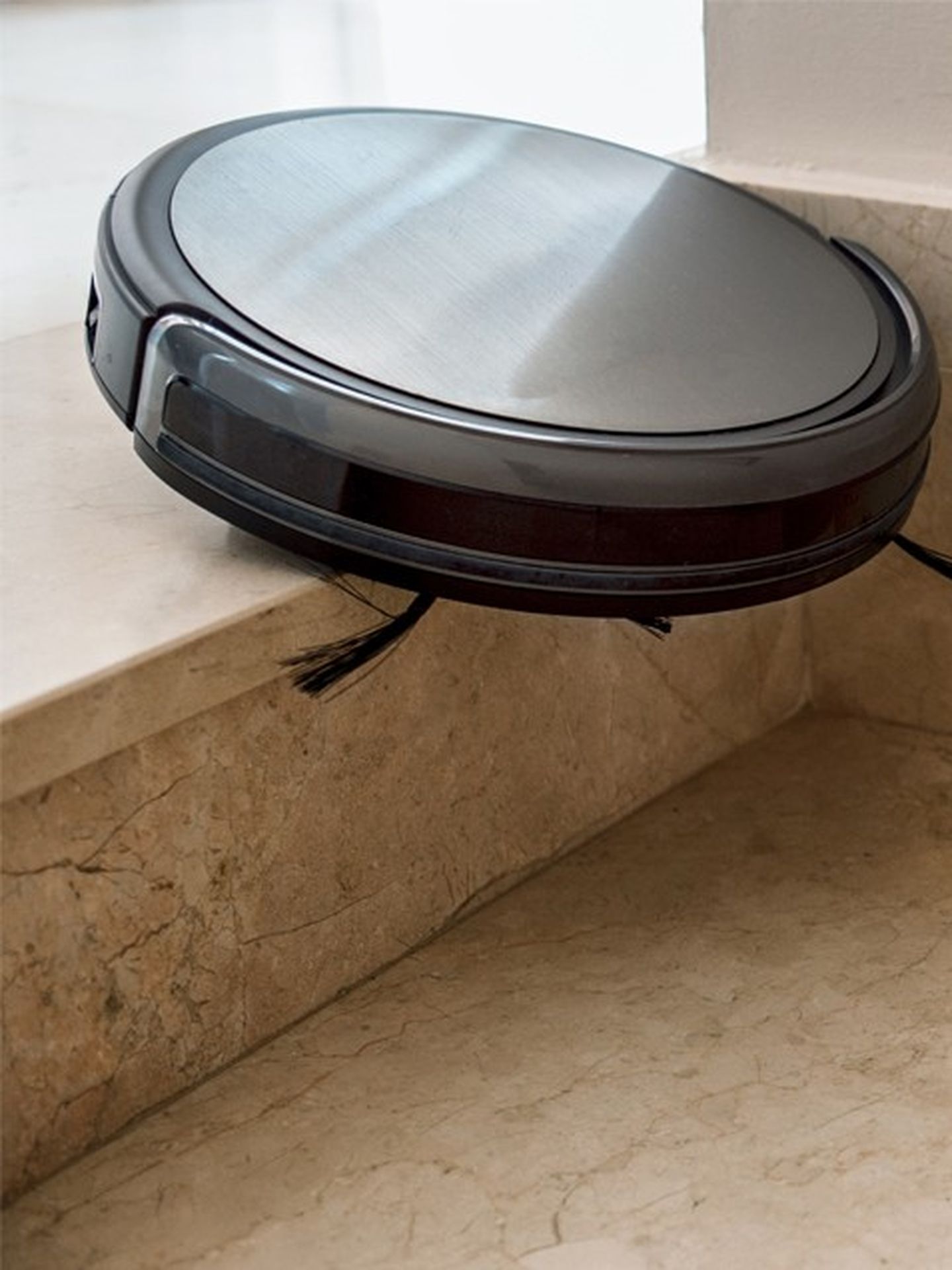 Ein Staubsaugerroboter fällt die oberste Stufe einer Treppe hinunter