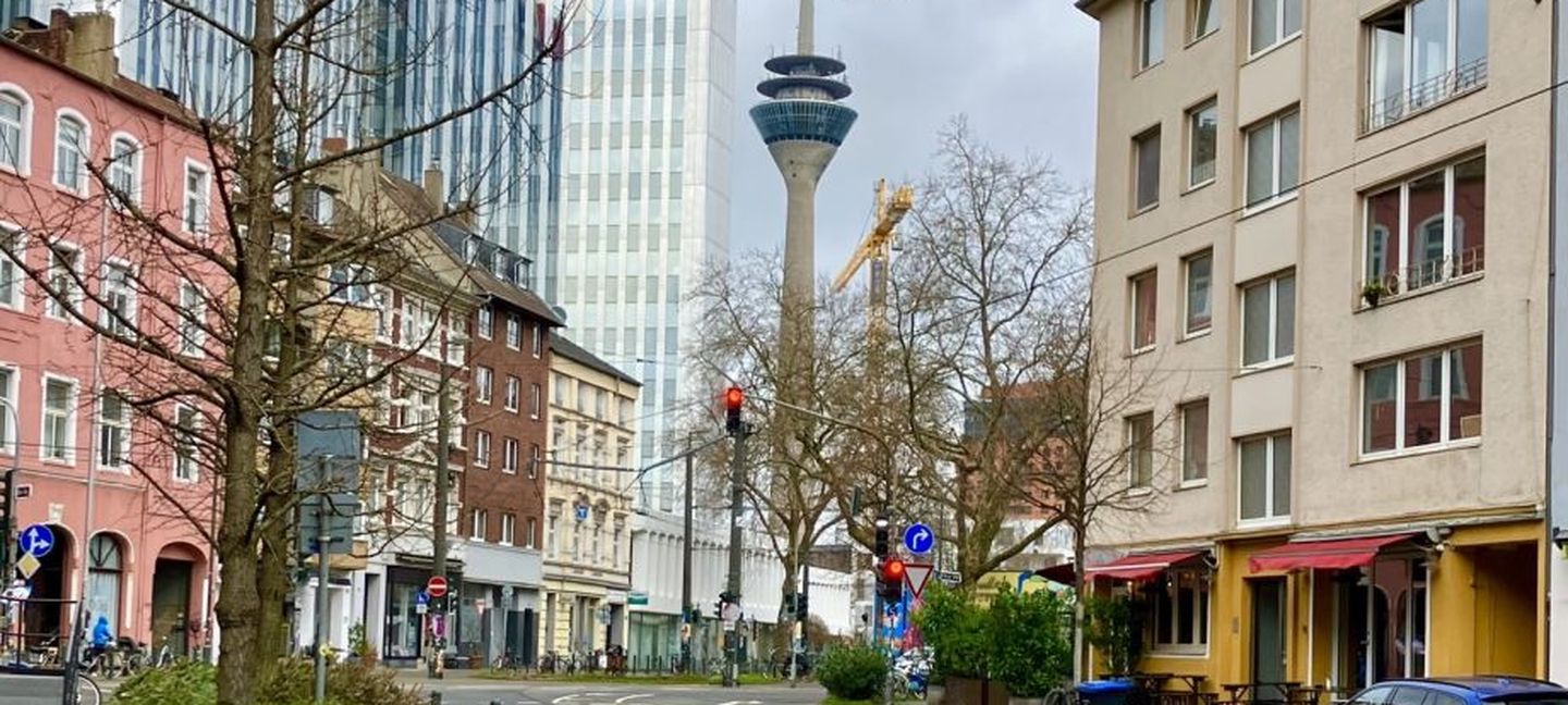 Eine Straße in Düsseldorf mit Blick auf den Rheinturm. 