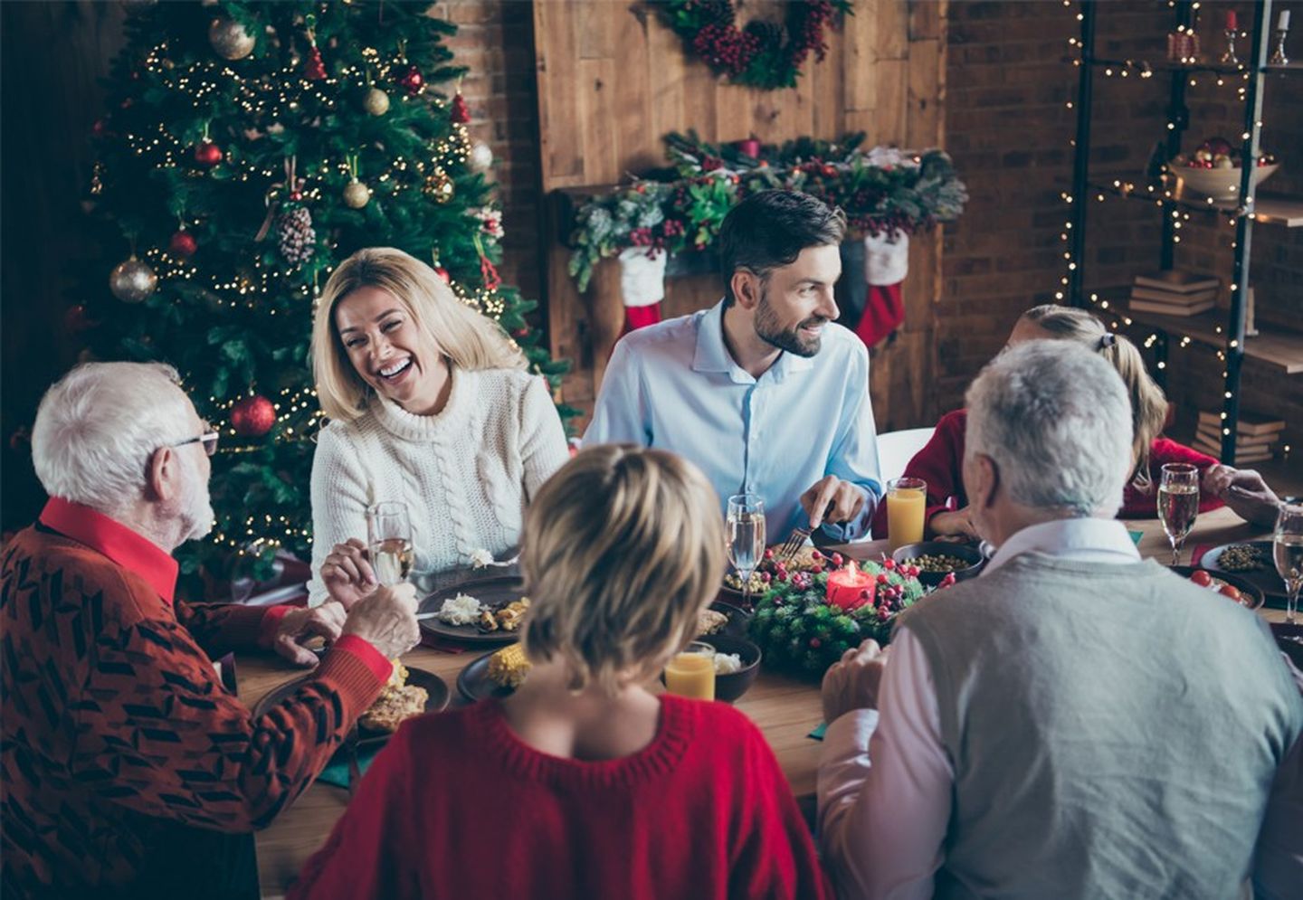 Eine Familie sitz Weihnachten um eine festlich gedeckte Tafel herum