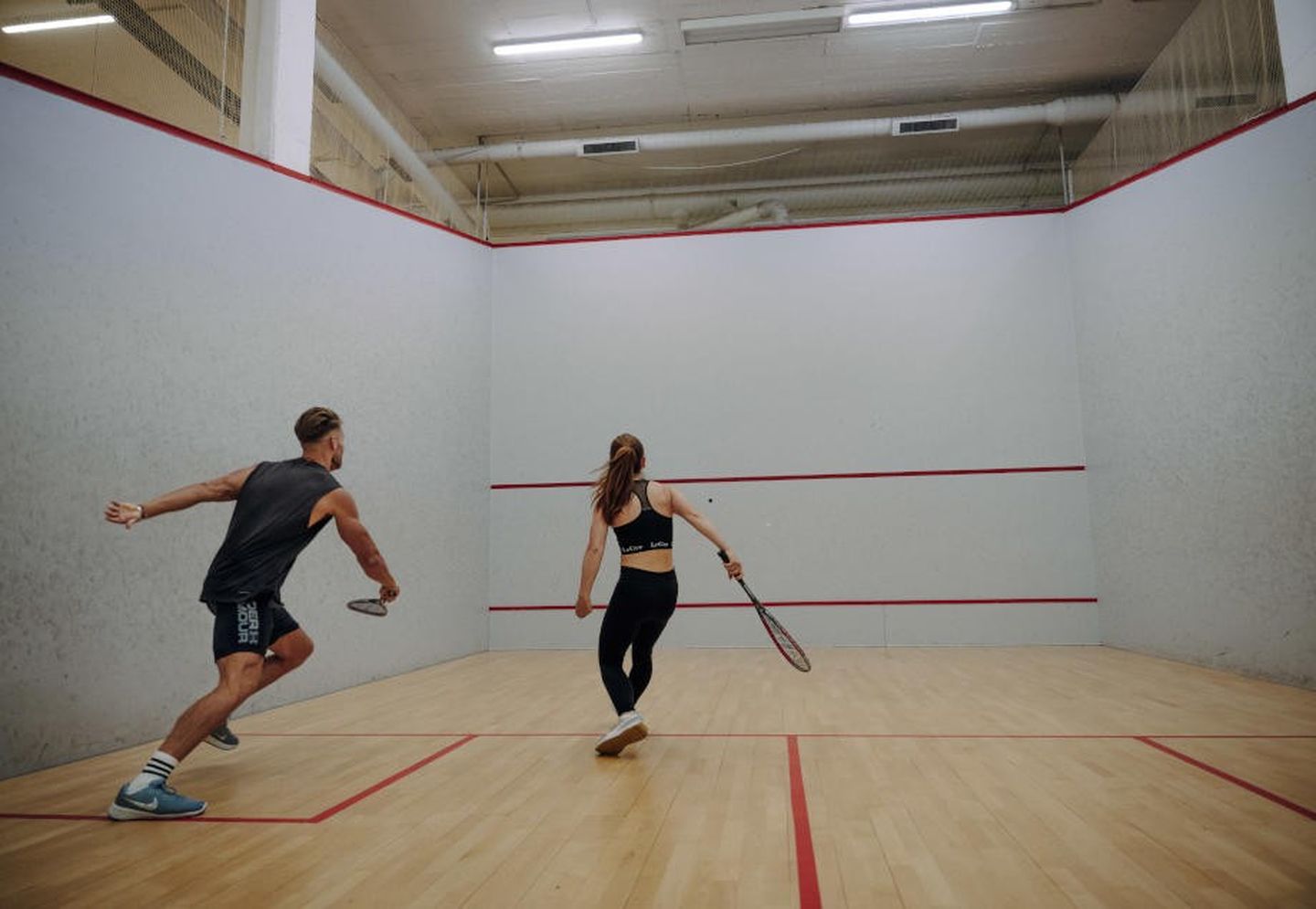 Ein Pärchen spielt Squash.