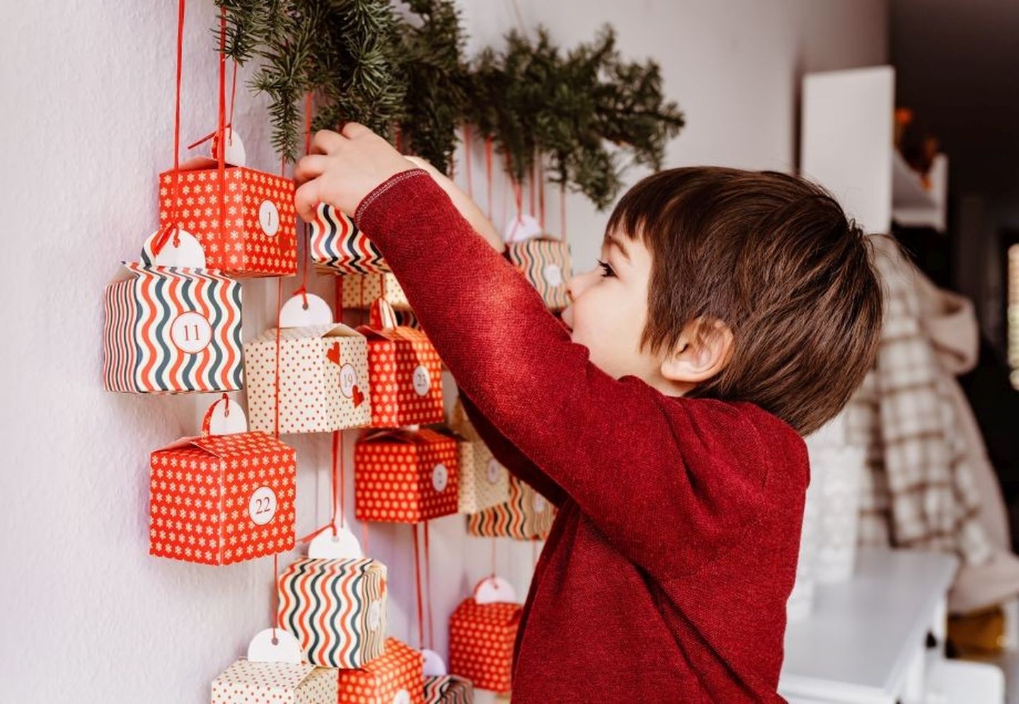 Weihnachten in anderen Ländern: Ein Kind steht vor seinem Adventskalender