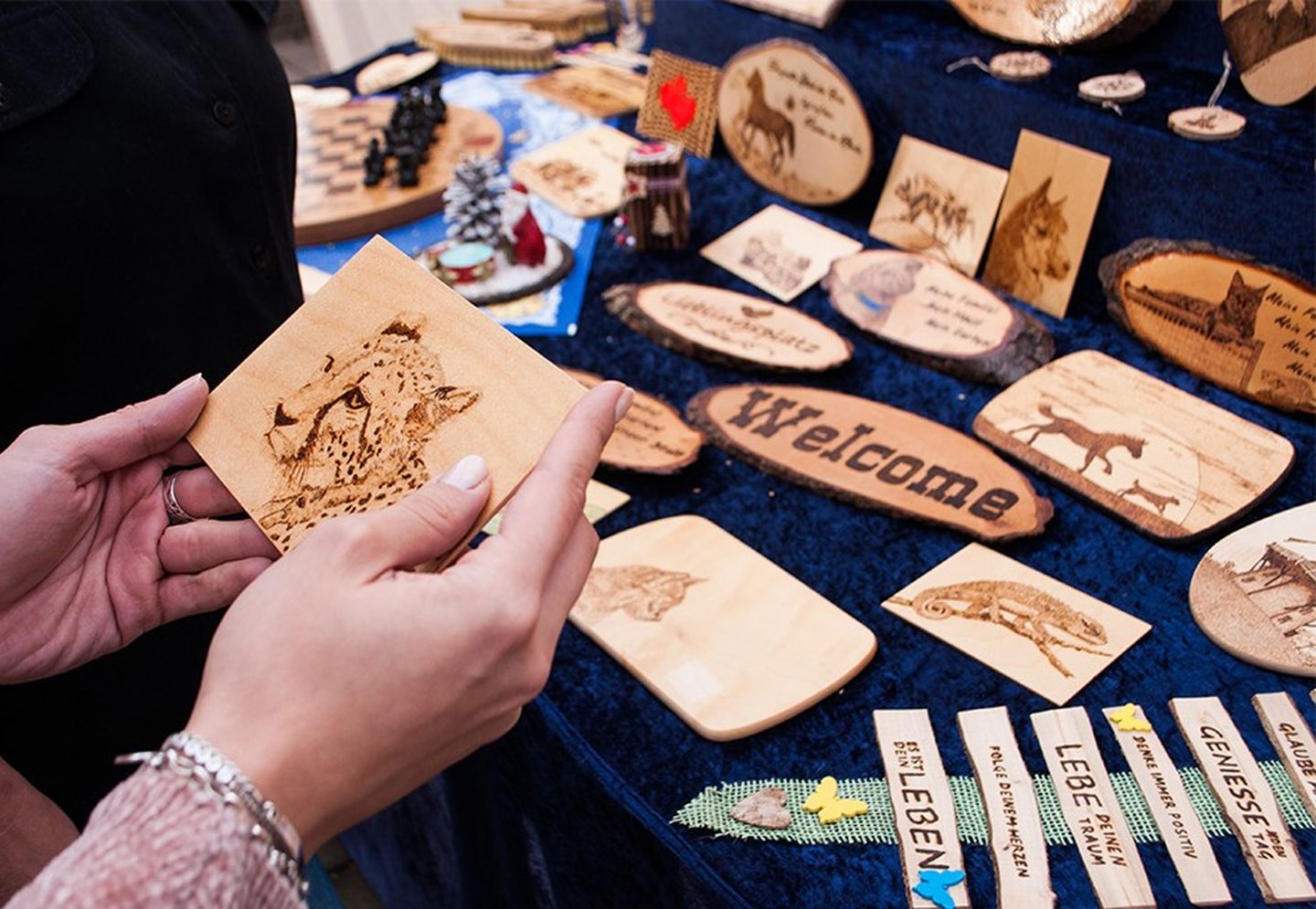 Am Stand liegen Namensschilder aus brandgemaltem Holz.