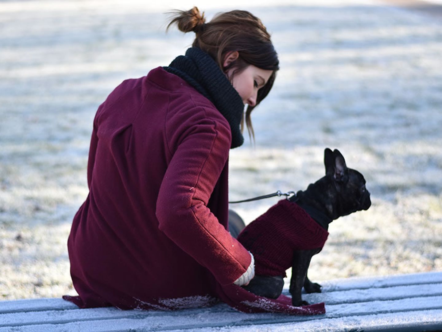 Jennifer Schleich von www.jestil.de mit ihrem Hund Frida auf einer Sitzbank im Winter.