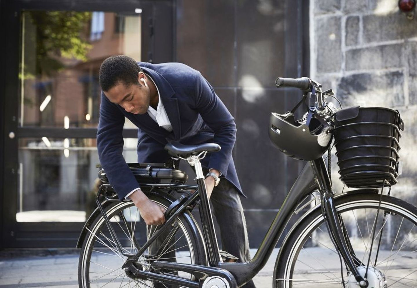 Mann schließt sein E-Bike im Stadt-Zentrum ab