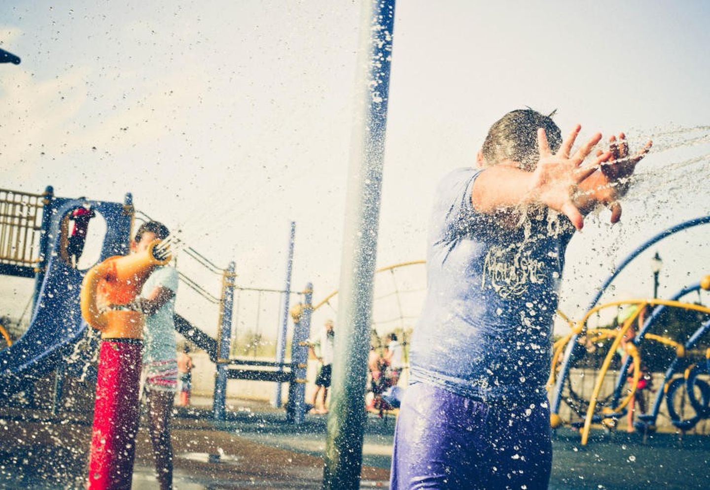 Kinder spielen auf einem Wasserspielplatz.