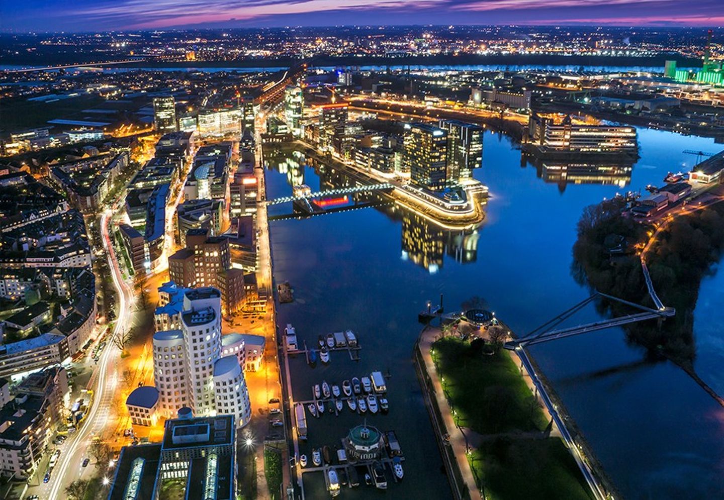 Nächtliche Luftaufnahme vom Lichtermeer des Düsseldorfer Medienhafens.