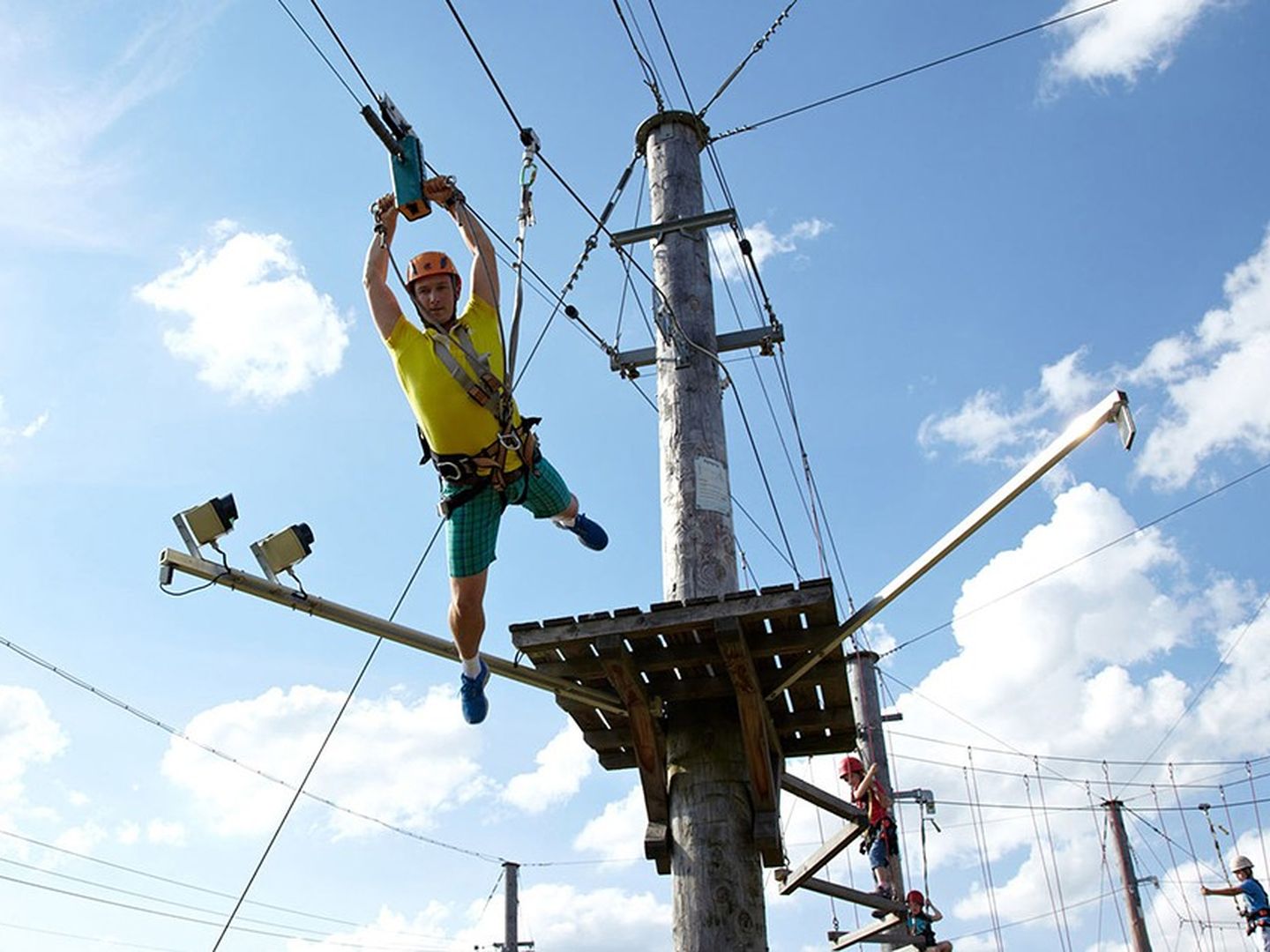 Ein Kletterer schwingt sich per Seilwinde von einer Plattform des Kletterparks im Alpenparadies Neuss.