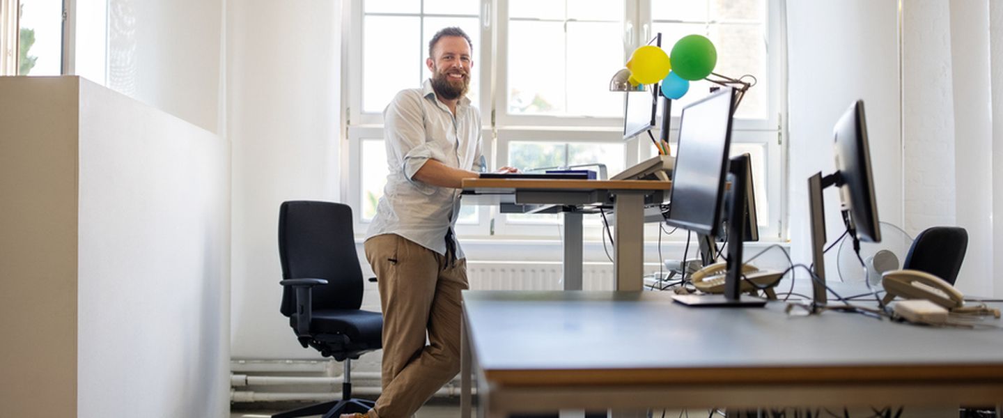 Mitarbeiter steht an ergonomischem Arbeitsplatz