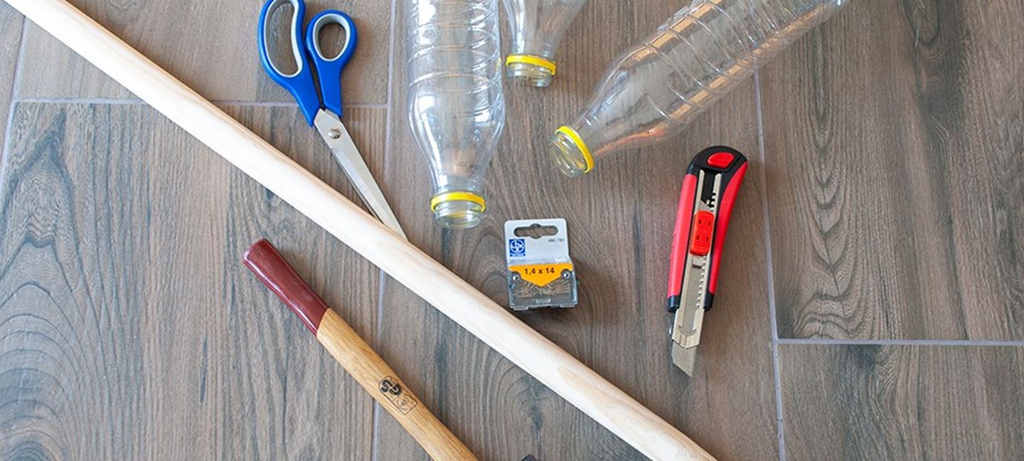 So baut man einen Besen: Holzstab, Plastikflaschen, kleine Nägel und stabiles Klebeband. Dazu Schere, Hammer und Teppichmesser.