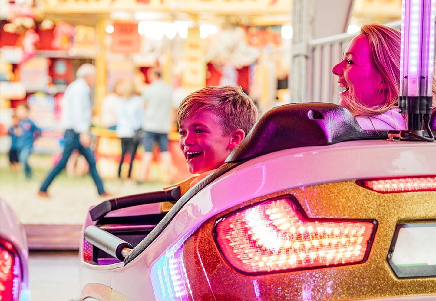 Mutter und Sohn haben Spaß beim Autoscooterfahren.