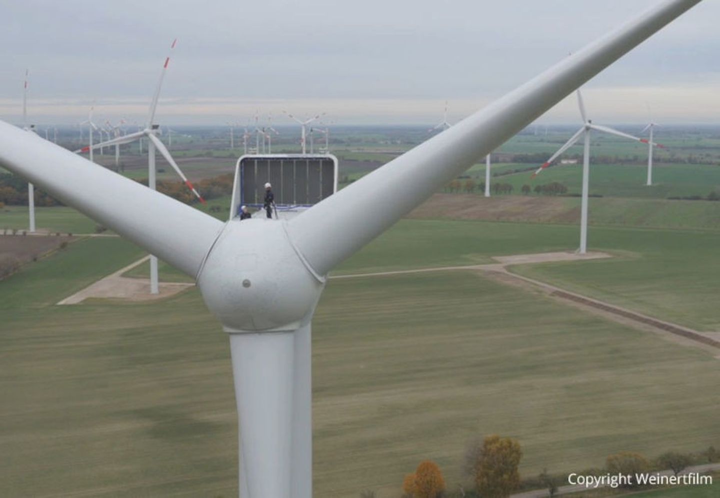 Arbeiter auf dem Maschinenhaus einer Windkraftanlage © Weinertfilm via Grünwerke 