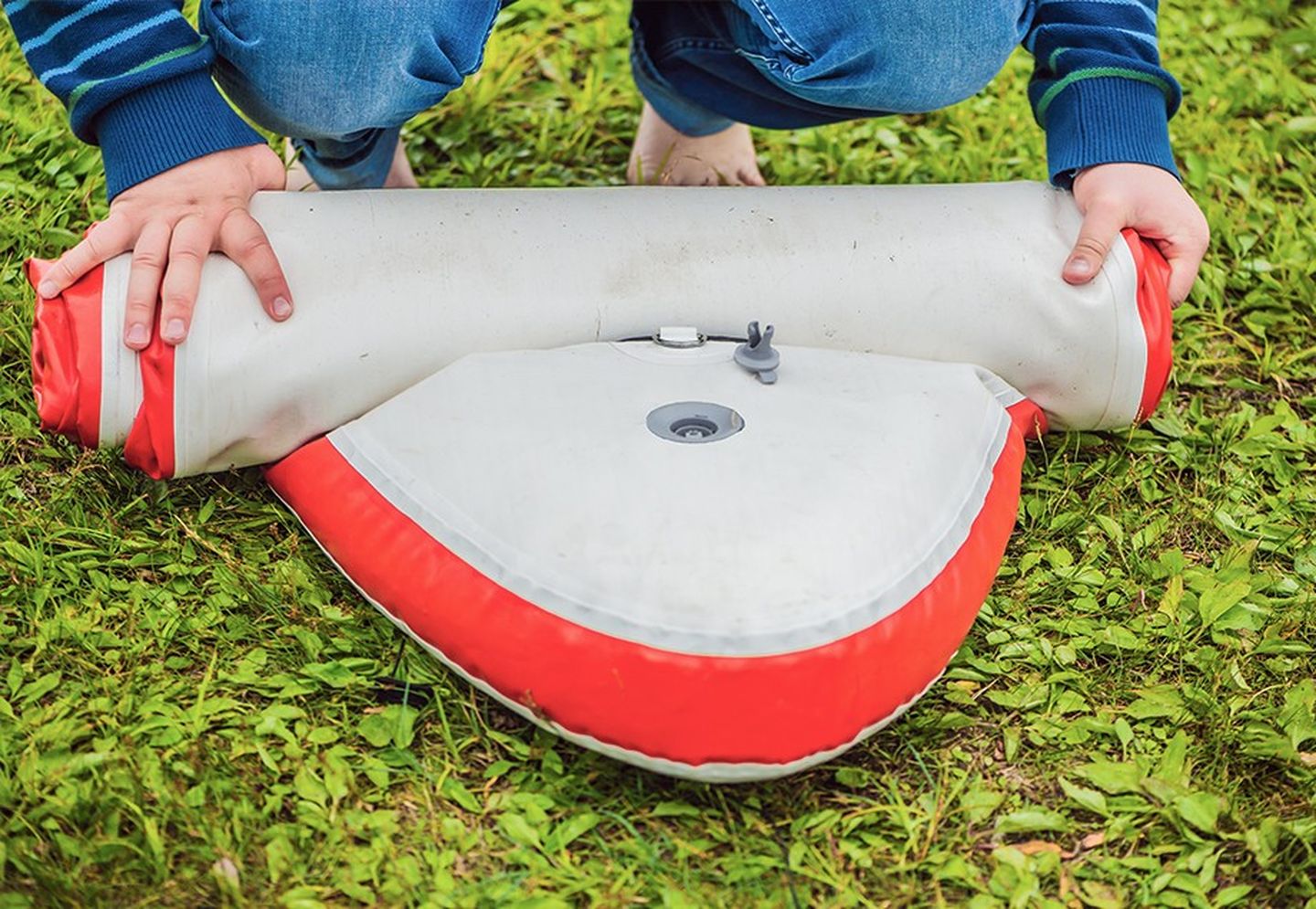 Jemand lässt die Luft aus seinem SUP-Board.