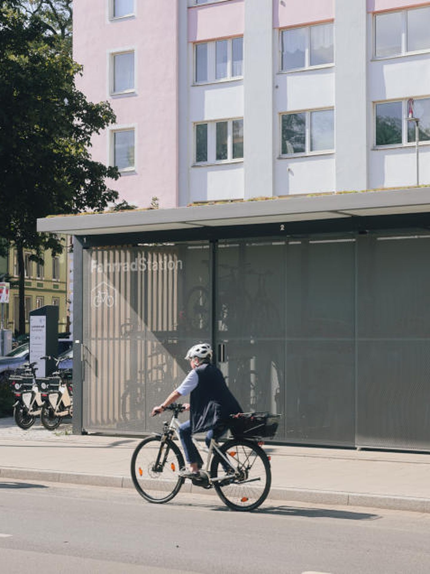 Zwei Radfahrer:innen passieren die Mobilitätsstation am Bachplätzchen in Düsseldorf. © Connected Mobility Düsseldorf GmbH
