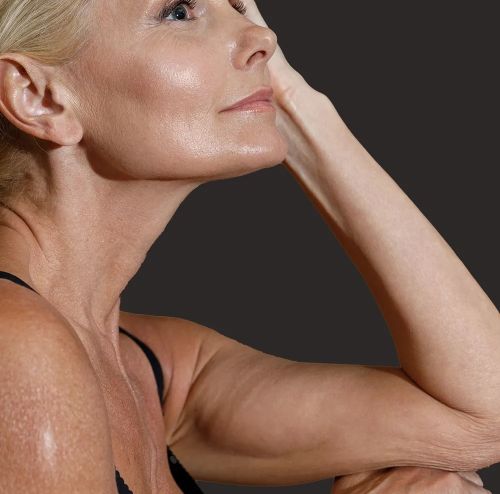 Blonde woman leaning on her elbow with a soft smile