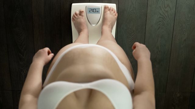 woman looking down on scales