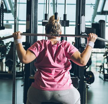 Woman in pink t-shirt on weight machine