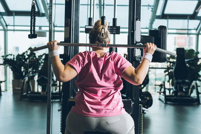 Woman in pink t-shirt on weight machine
