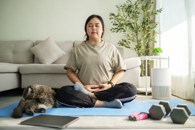 woman mediating on yoga mat