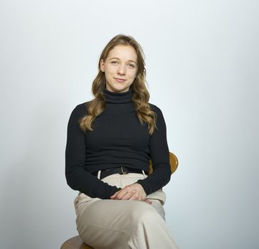 Woman in black top sitting and smiling to camera