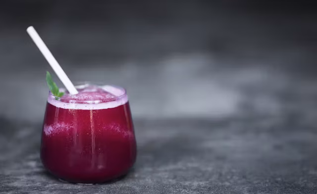a fruity purple-coloured cocktail with protruding white straw