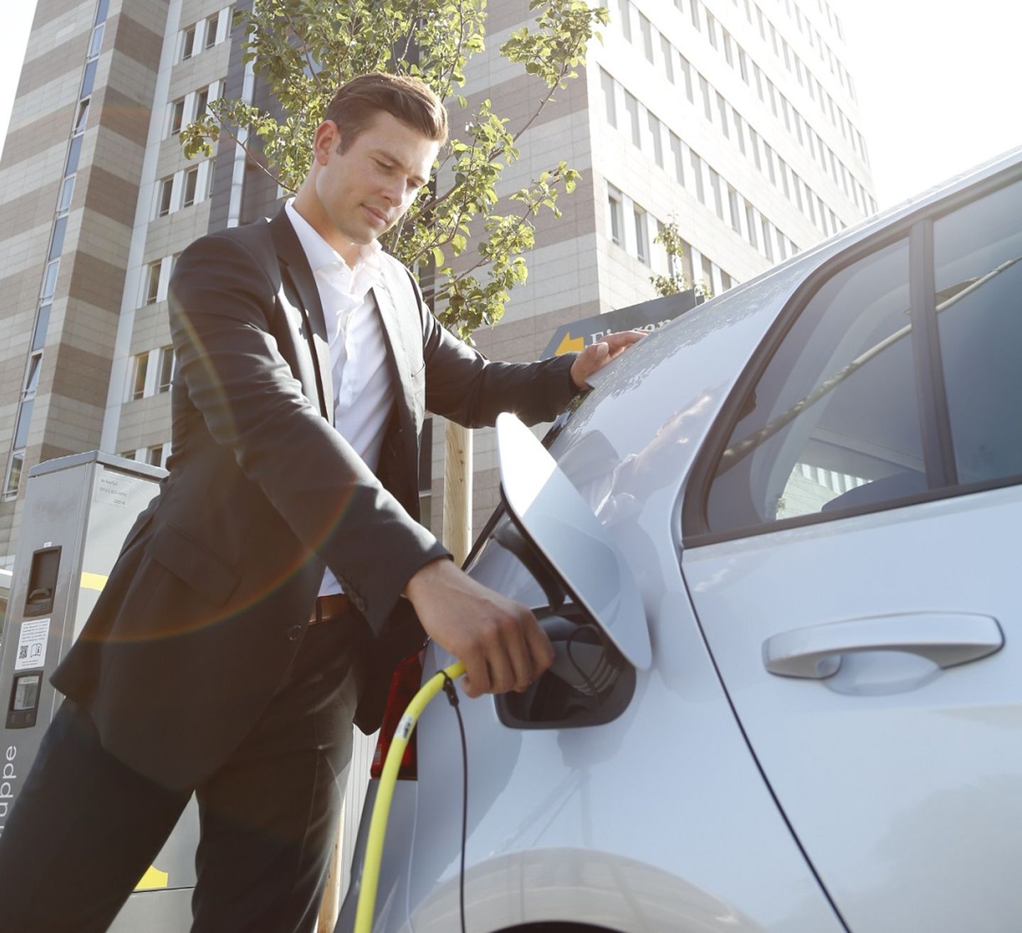 Ein Mann lädt sein Elektroauto an einer Ladestation