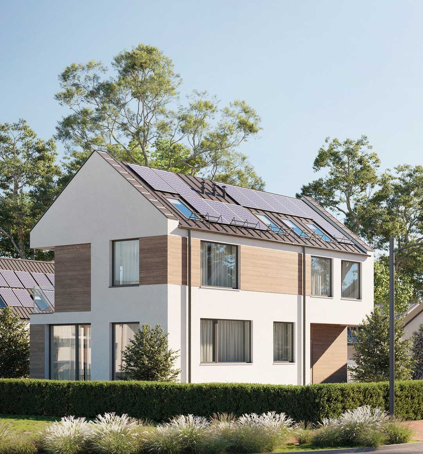 Häuser im Neubaugebiet mit Solarkollektoren auf dem Dach und Windrädern im Hintergrund.