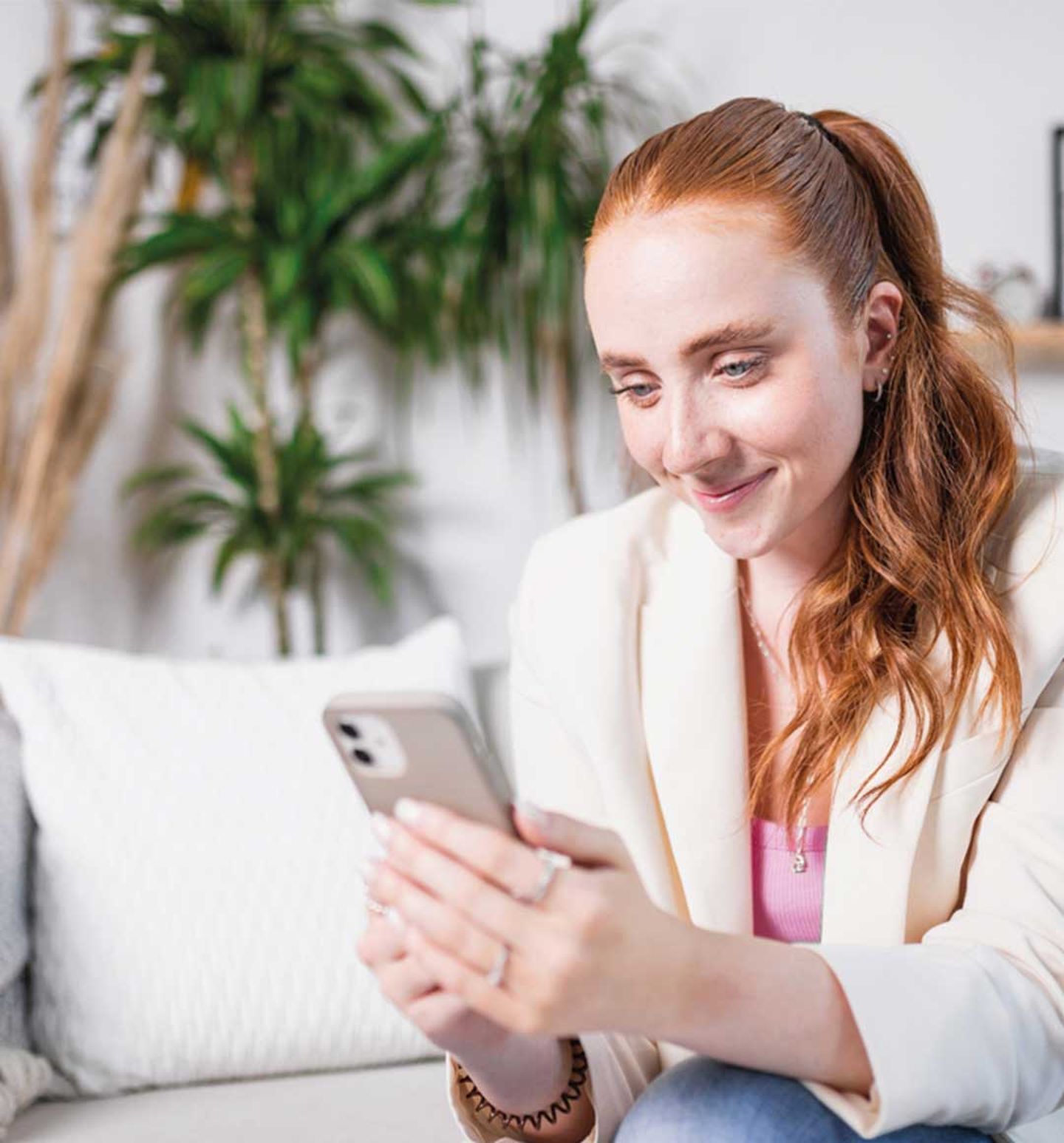 Eine rothaarige Frau meldet sich auf ihrem Smartphone für den Stadtwerke Düsseldorf Newsletter an