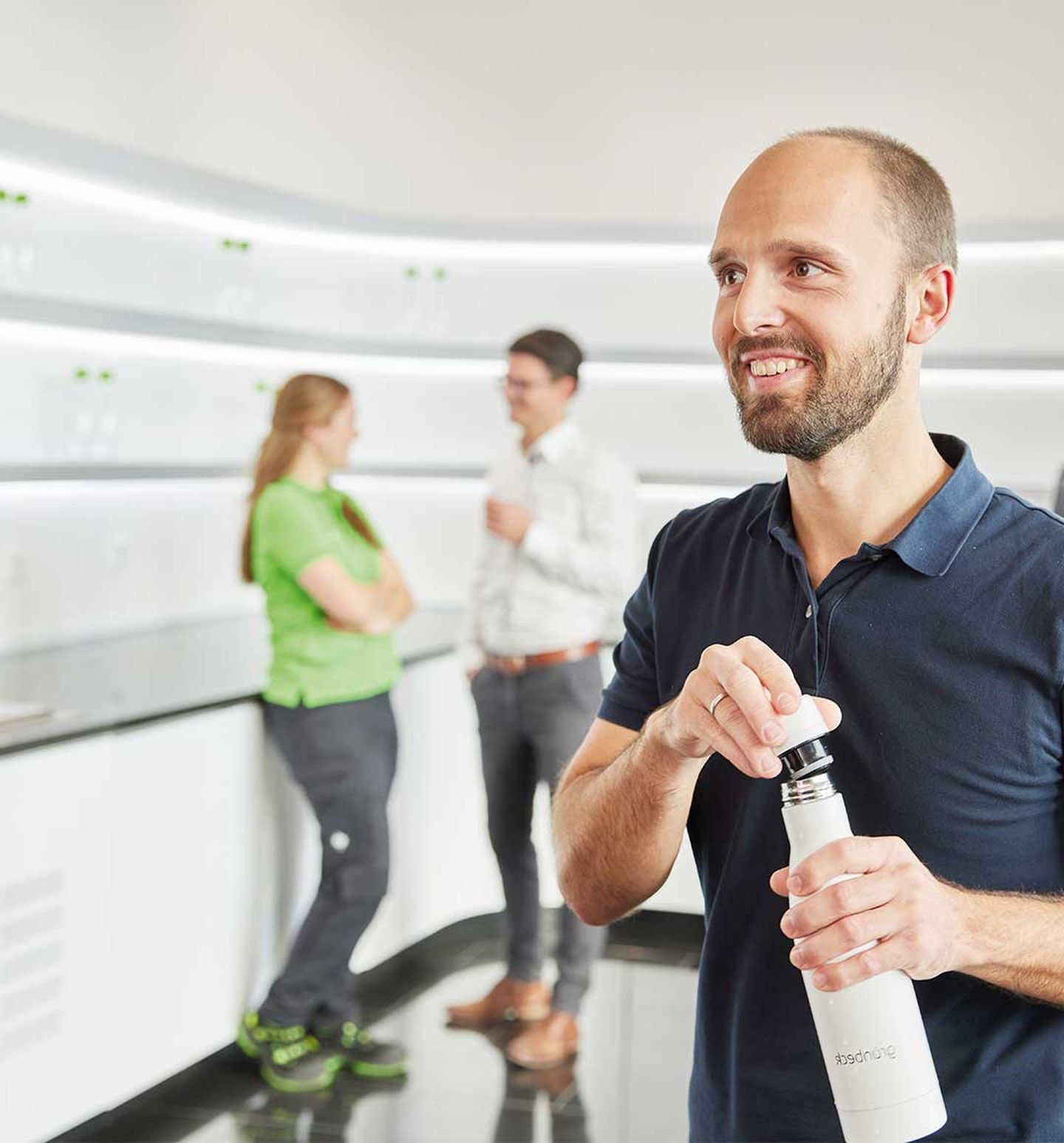 Ein Mann füllt sich seine Trinkflasche am Wasserspender auf