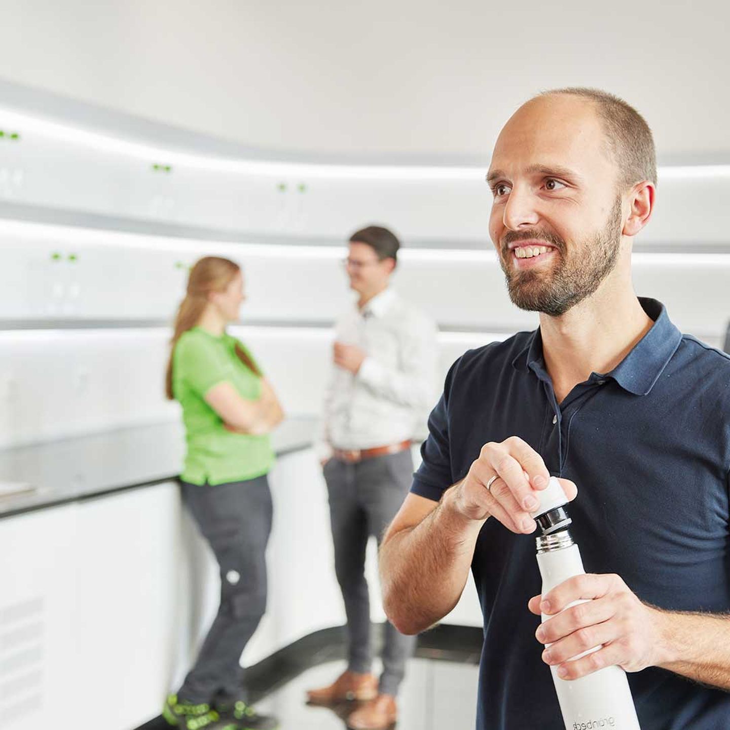 Ein Mann füllt sich seine Trinkflasche am Wasserspender auf