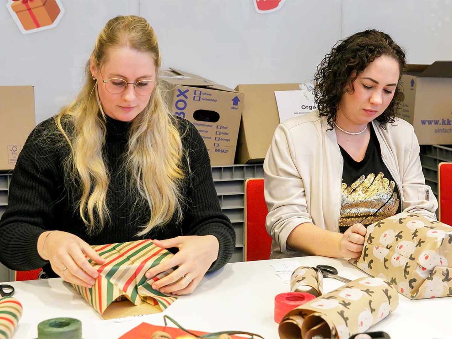 Zwei Mitarbeiterinnen der Stadtwerke Düsseldorf packen Geschenke ein