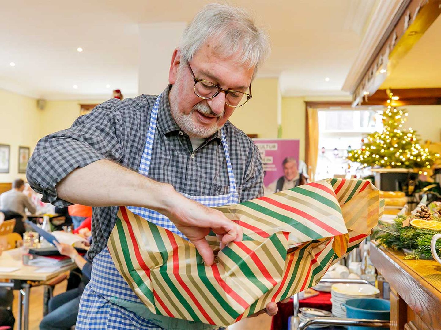 Ein Mann packt ein Geschenk aus