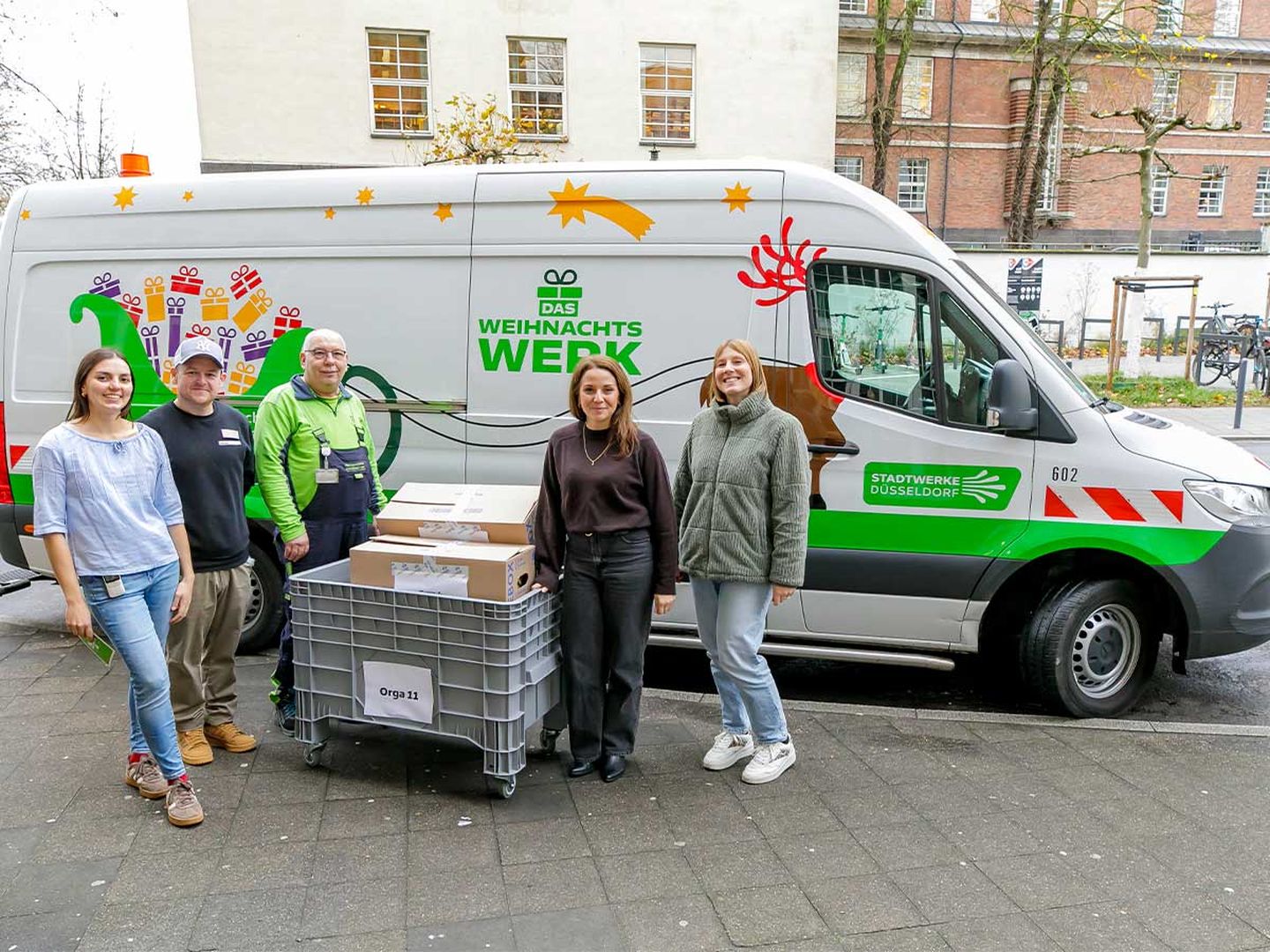 Mitarbeitende der Stadtwerke Düsseldorf vor dem Mobil des Weihnachtswerks