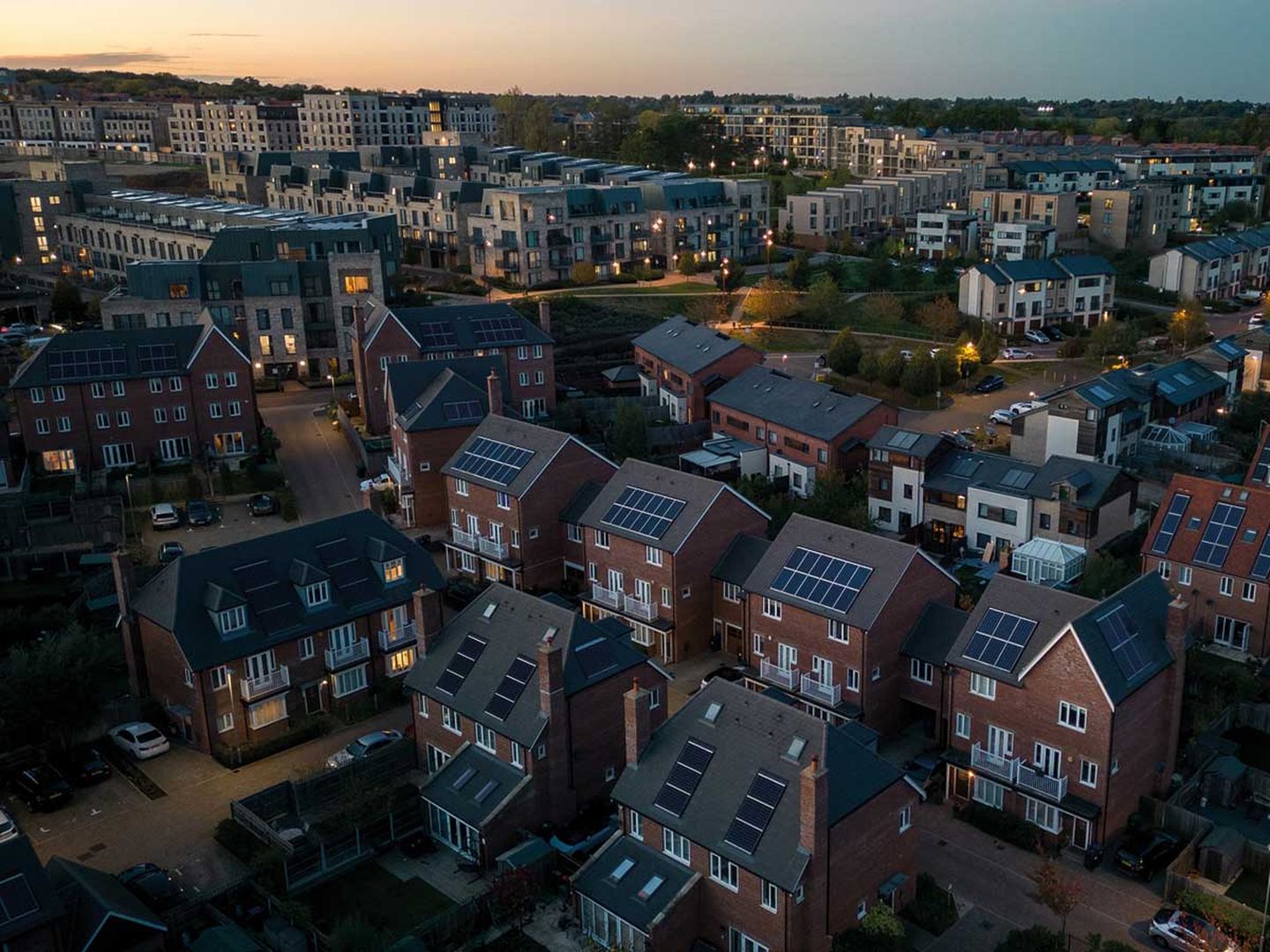 Luftaufnahme einer modernen, solarbetriebenen Wohnsiedlung in der Abenddämmerung. © Richard Newstead / Moment via Getty Images