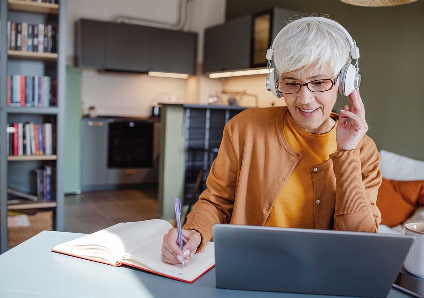 Frau nimmt zu Hause an einem Web-Seminar für Photovoltaik teil. © blackCAT / E+ via Getty Images. © blackCAT / E+ via Getty Images.